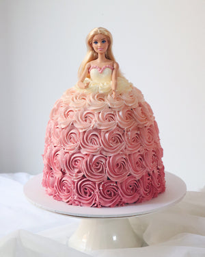 Barbie doll cake with pink and red rose design on a white background