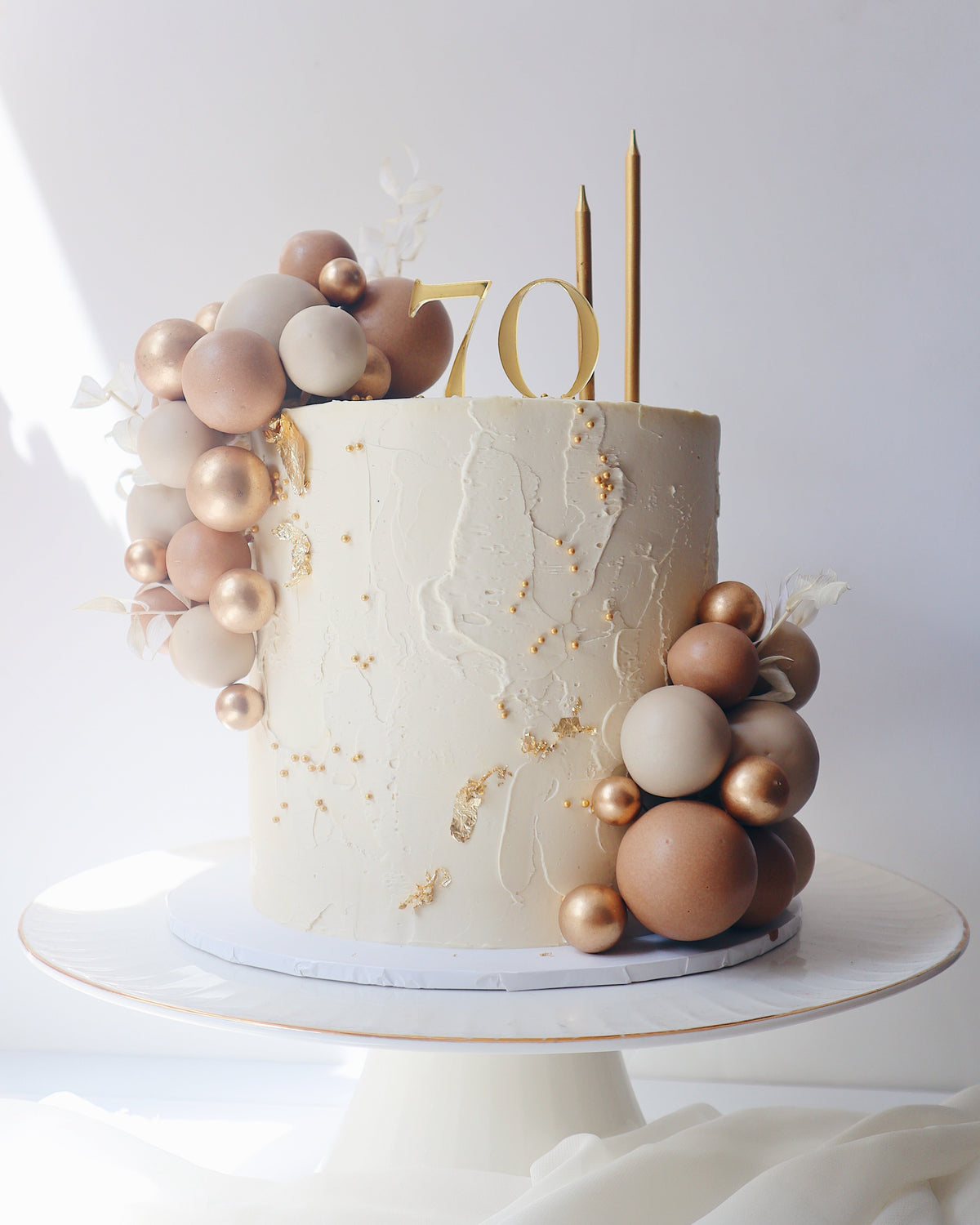 Decorative cake with balloons and a number 70 candle on a white background