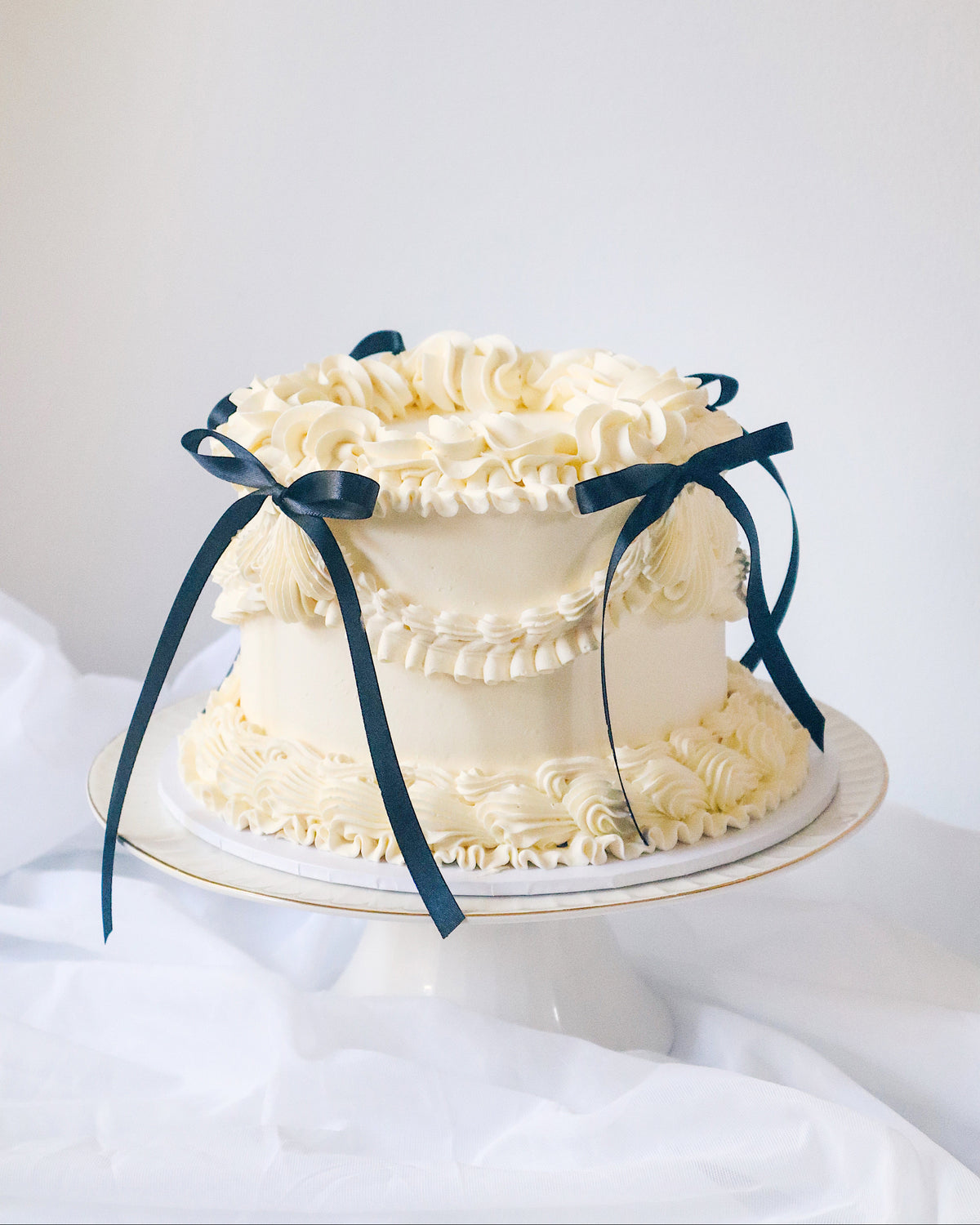 White cake with decorative ribbons on a white background